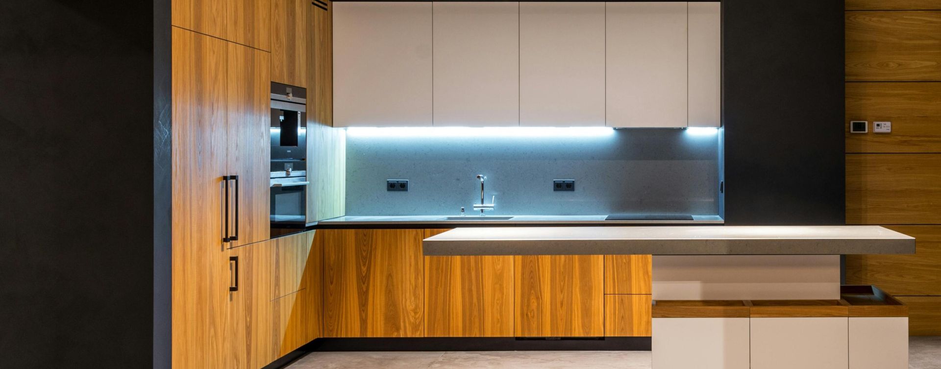 Interior of modern cottage with marble floor and spacious kitchen with wooden furniture and floating tabletop