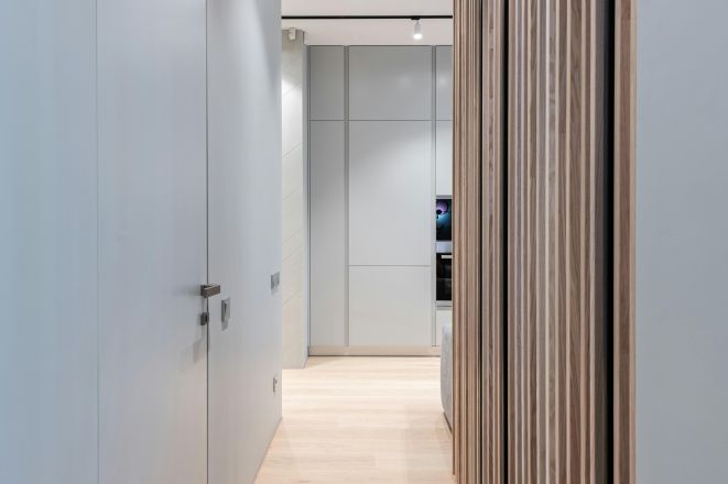 Modern empty hallway interior with door and walls leading to light spacious room