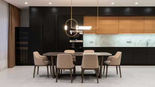 Sleek, minimalist kitchen interior featuring contemporary furnishings and modern lighting.
